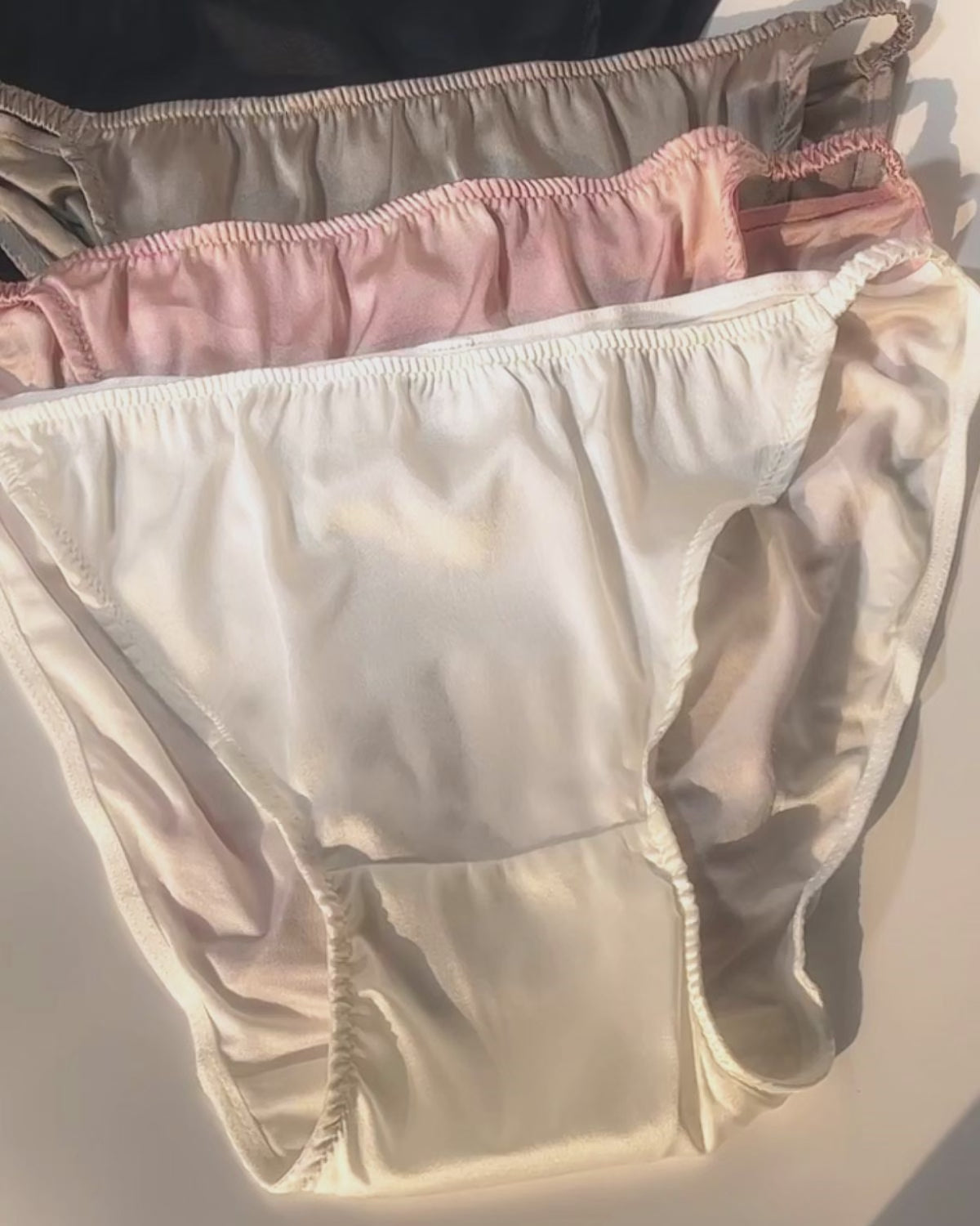 Detailed showcase of women’s breathable silk string bikini panties in multiple colors.